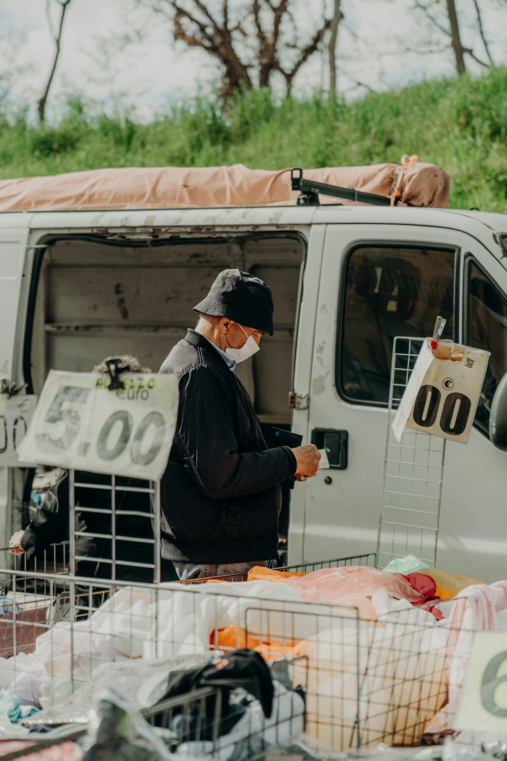 a man wearing a face mask standing in front of a van