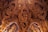 Intricately carved wooden interior featuring detailed figures and ornate patterns, reminiscent of traditional Eastern art and architecture. The craftsmanship showcases complex motifs and human-like figures interwoven with decorative elements.