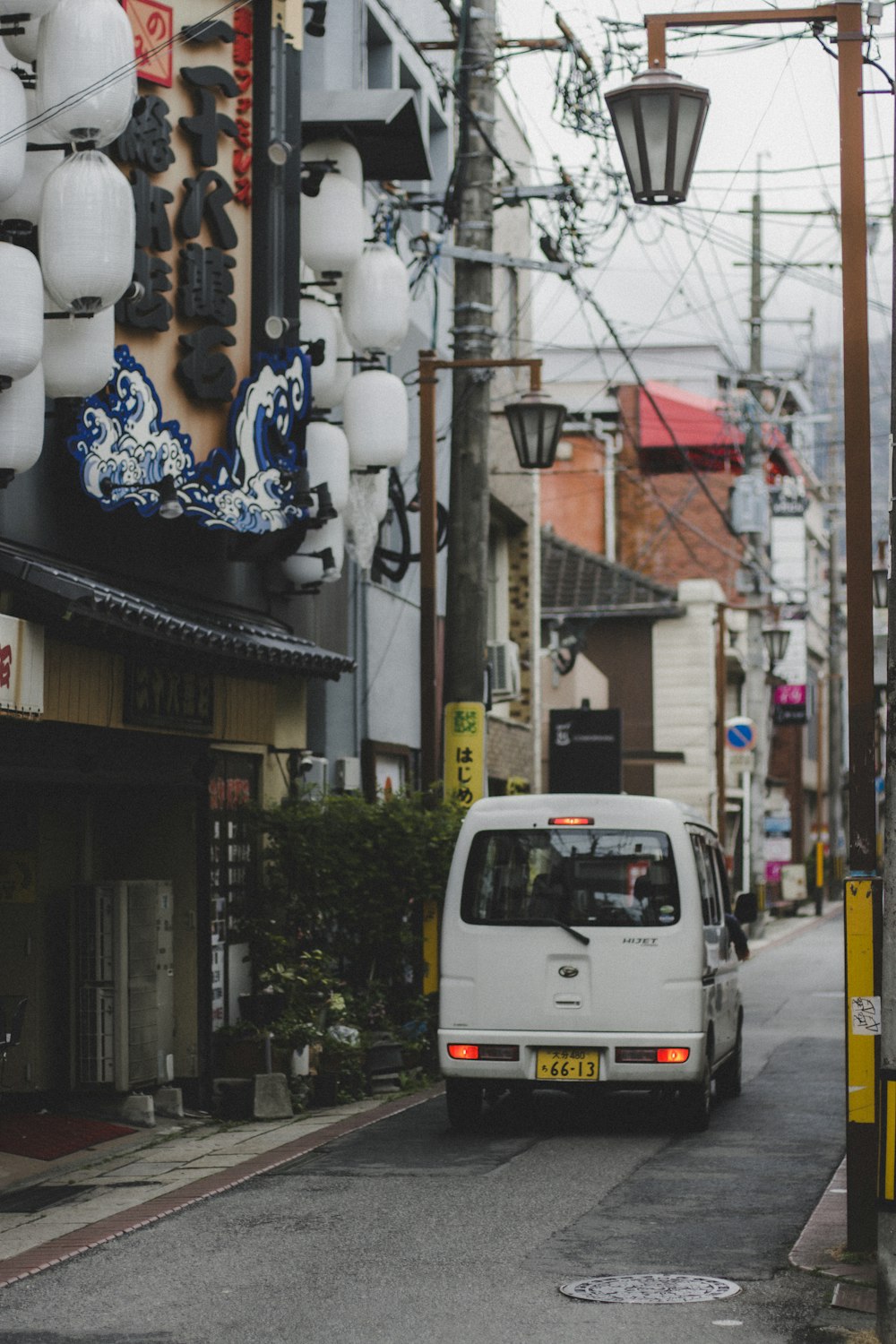 高層ビルの隣の通りを走る白いバン