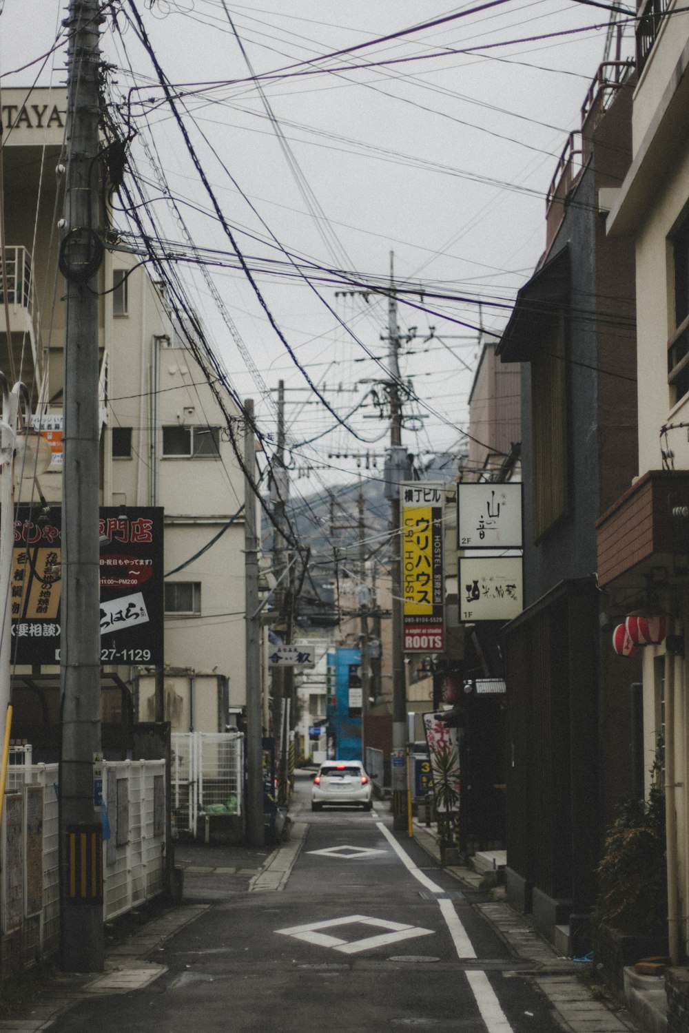 脇に車が停まっている街の通り