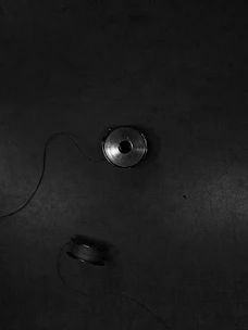 Close-up of elegant golden thread spools on dark charcoal fabric background.