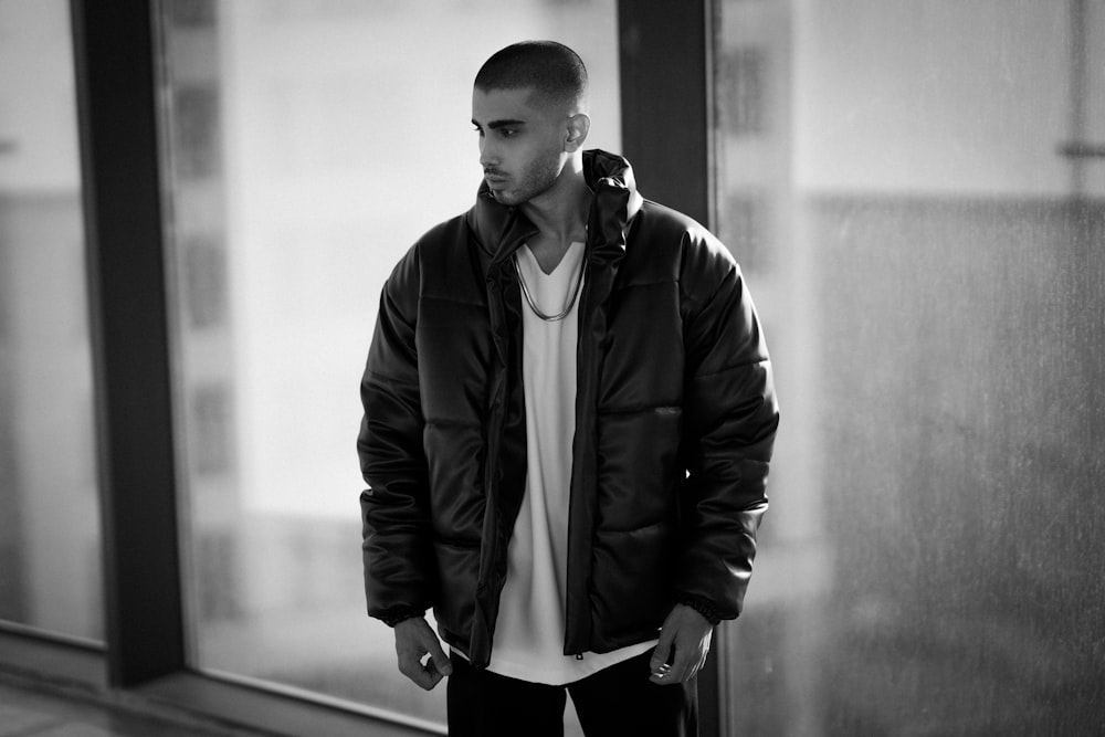 a man standing in front of a window in a black and white photo