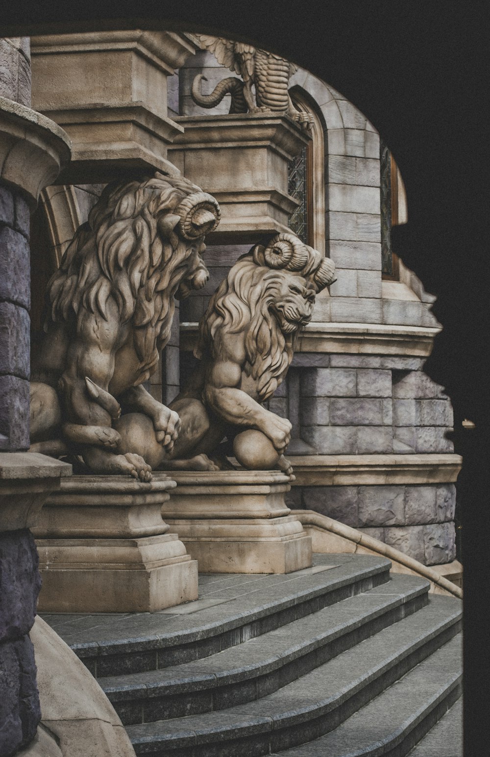 a couple of lions sitting on top of a set of stairs