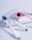 Three coiled USB cables in pastel colors, including blue, pink, and white, are arranged in a visually appealing manner. The cables are neatly coiled, displaying their colorful braided texture against a plain light background.