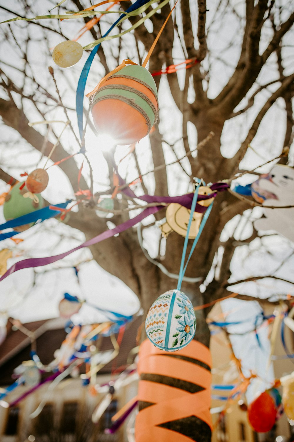 a close up of a kite hanging from a tree
