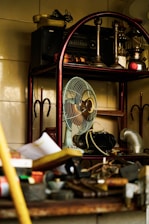 a fan sitting on top of a wooden shelf