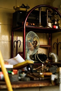 a fan sitting on top of a wooden shelf
