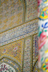 Detailed shot of colorful wall painting with floral patterns indoors.