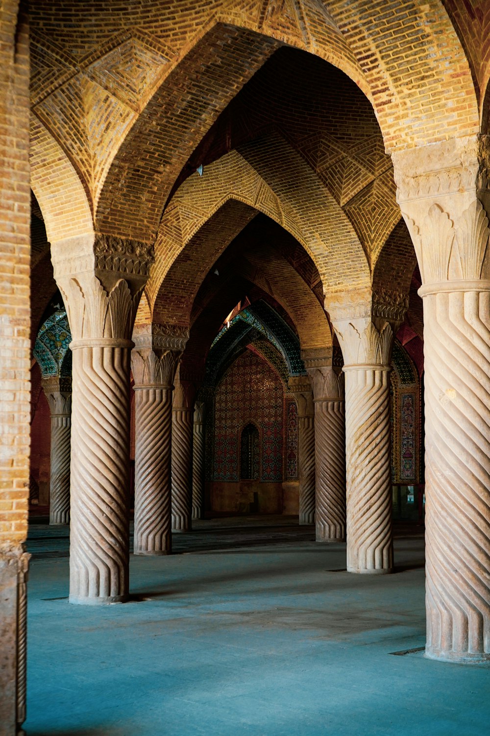 a large room with columns and a clock on the wall