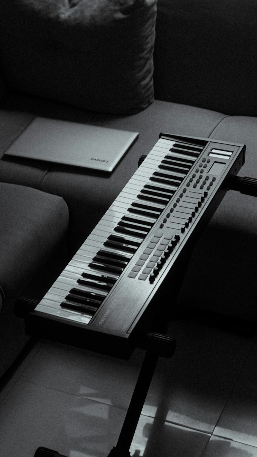 Foto zum Thema Eine tastatur, die auf einem tisch neben einer couch sitzt –  Kostenloses Bild zu Instrument auf Unsplash