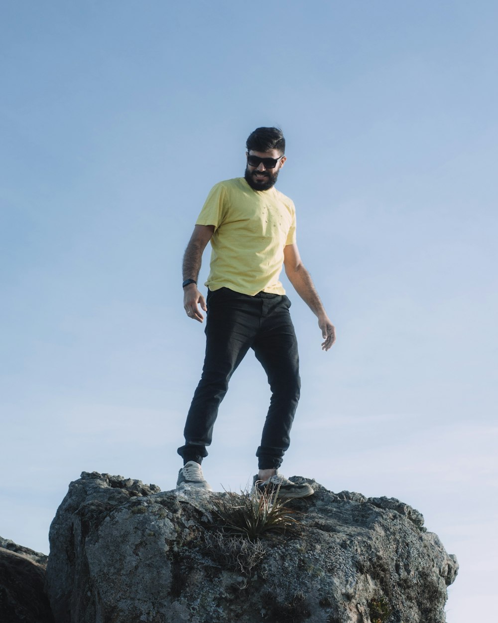 a man standing on top of a large rock