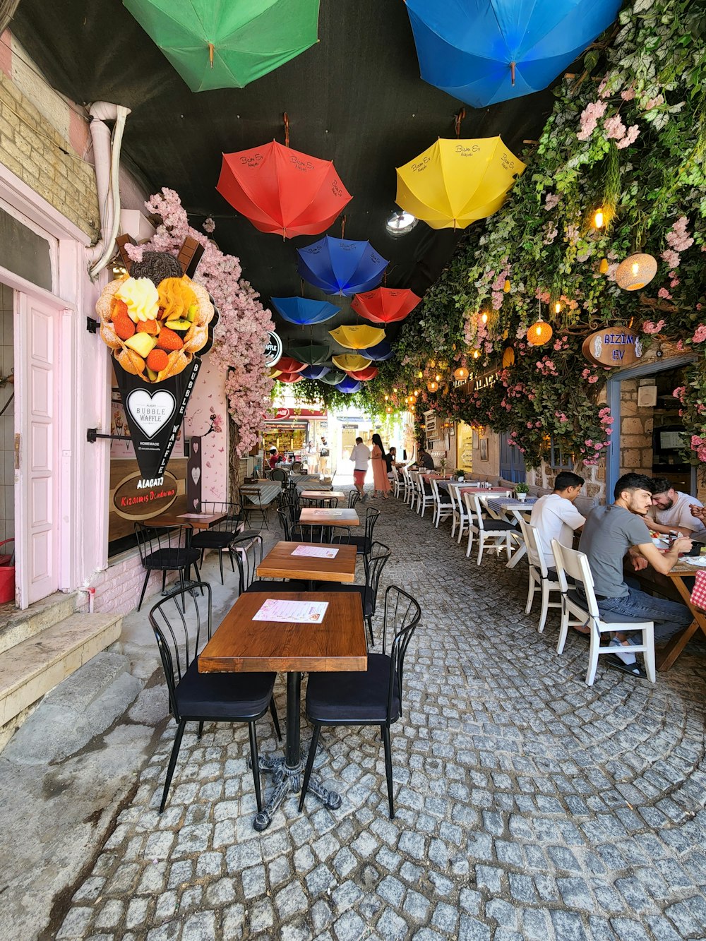 a restaurant with tables and umbrellas hanging from the ceiling