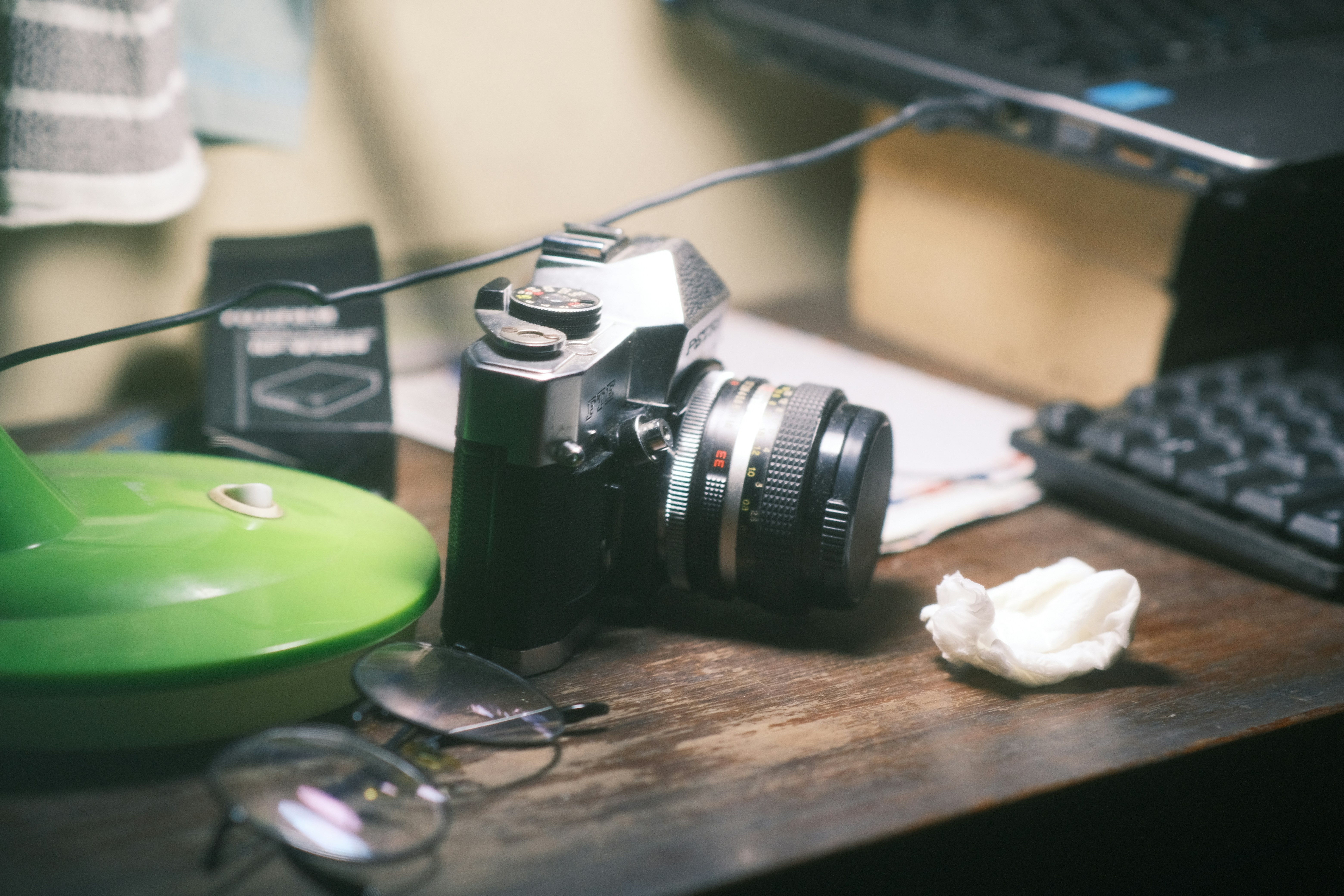 a camera sitting on top of a wooden table next to a keyboard