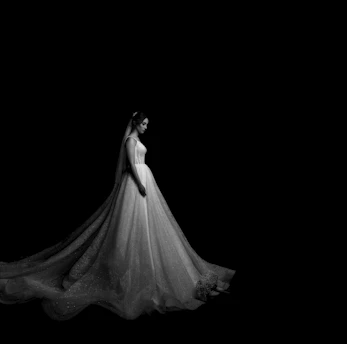 a woman in a white dress is standing in the dark