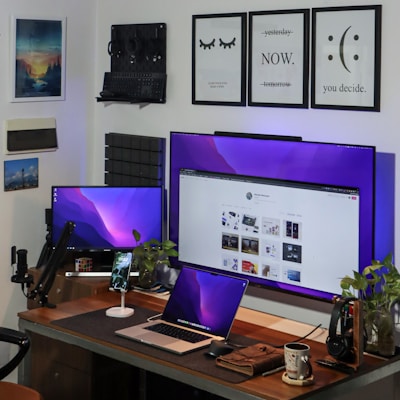 A modern workspace with multiple digital devices displaying interconnected applications.