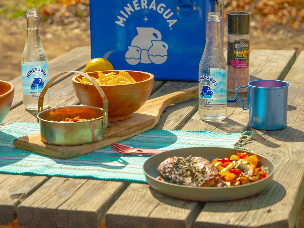 a wooden table topped with bowls of food