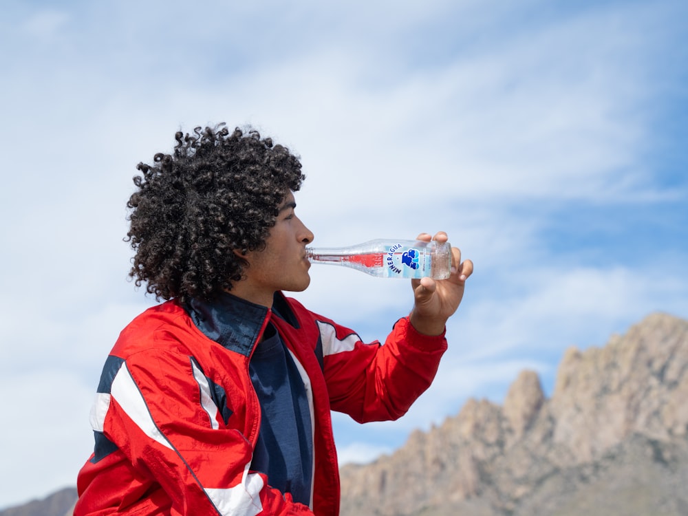 a man drinking water from a plastic bottle