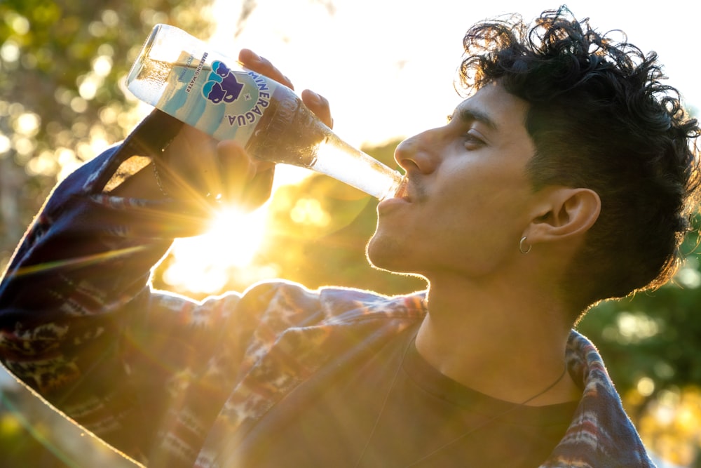 a man drinking water from a plastic bottle