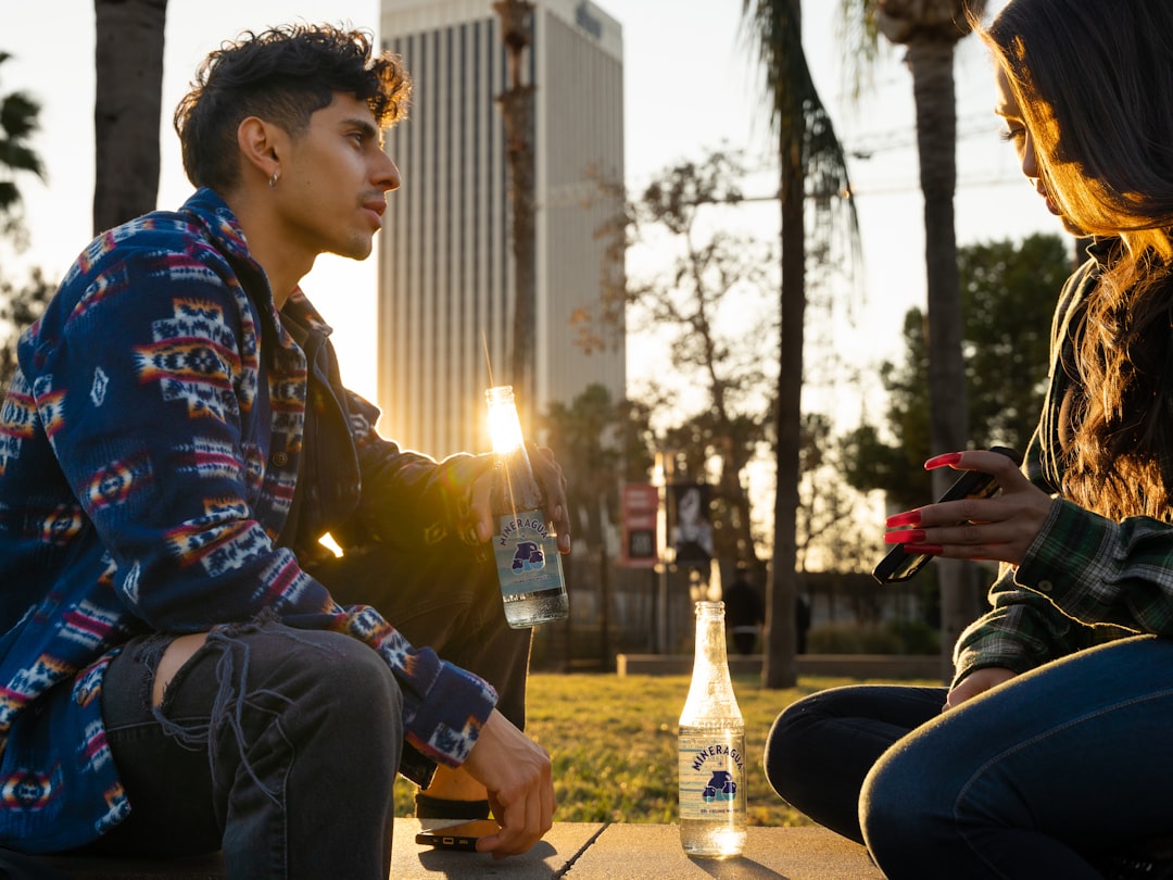 a man and a woman sitting on a bench next to each other,