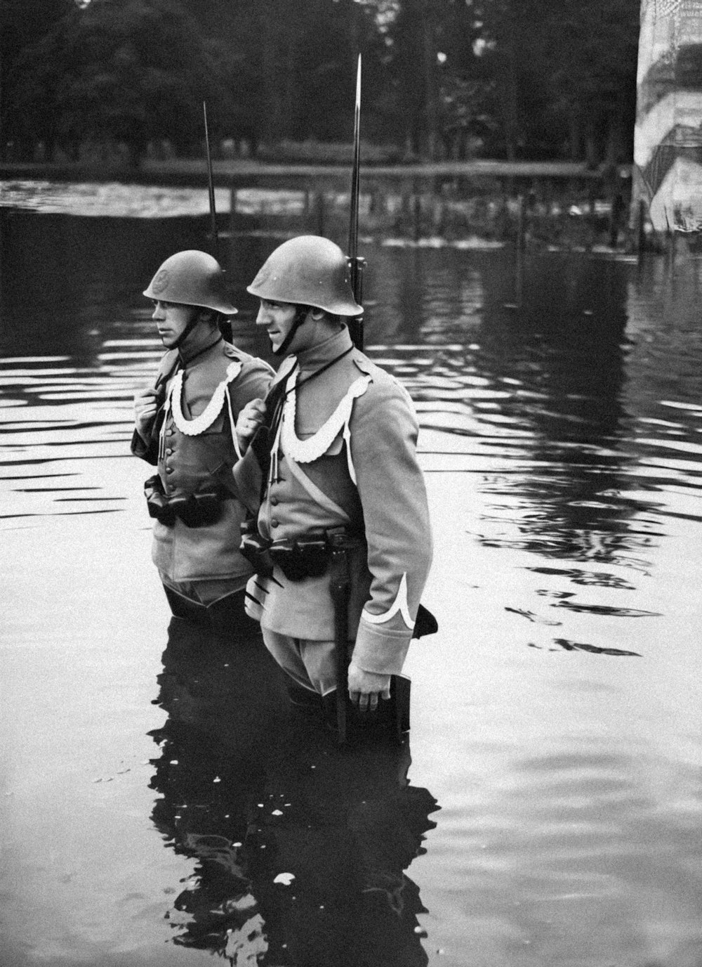 a couple of men standing in the water