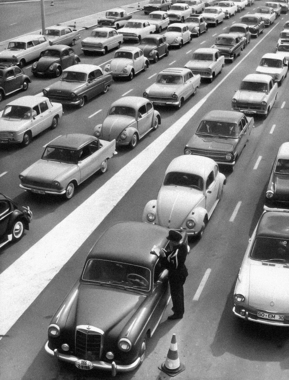 a black and white photo of a highway filled with cars