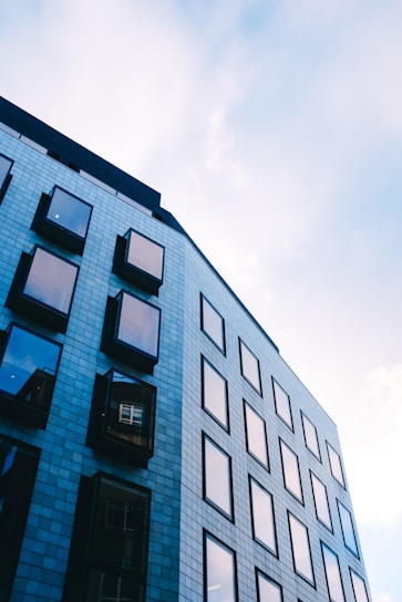 Sophisticated office building exterior in deep navy blue and slate grey tones under a clear sky.