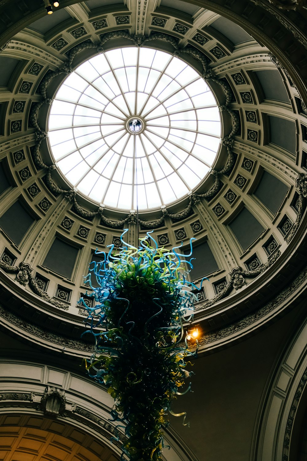 a tall glass vase sitting under a domed ceiling