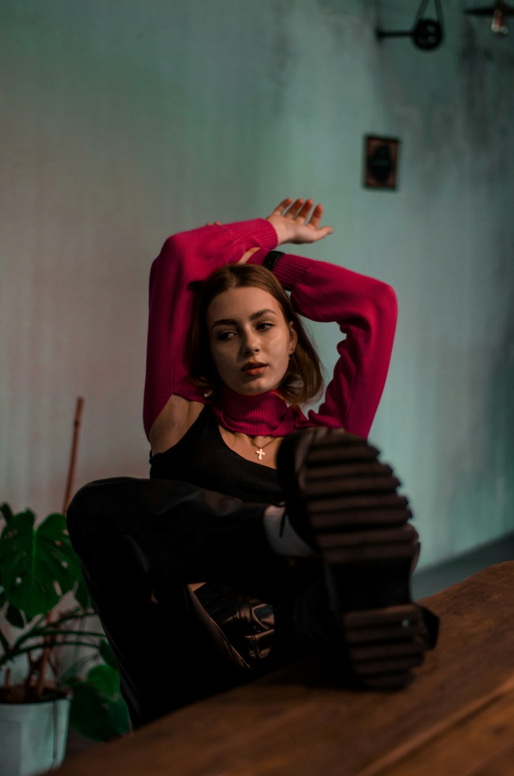 a woman sitting on top of a wooden table