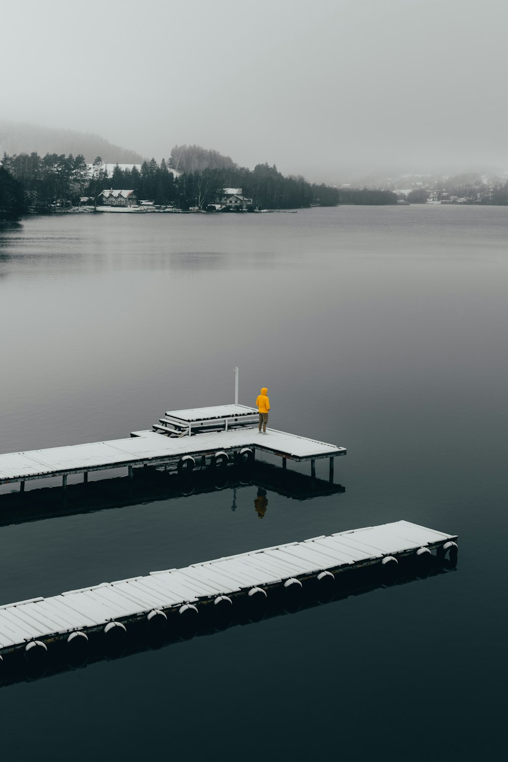 a person standing on a dock in the middle of a lake