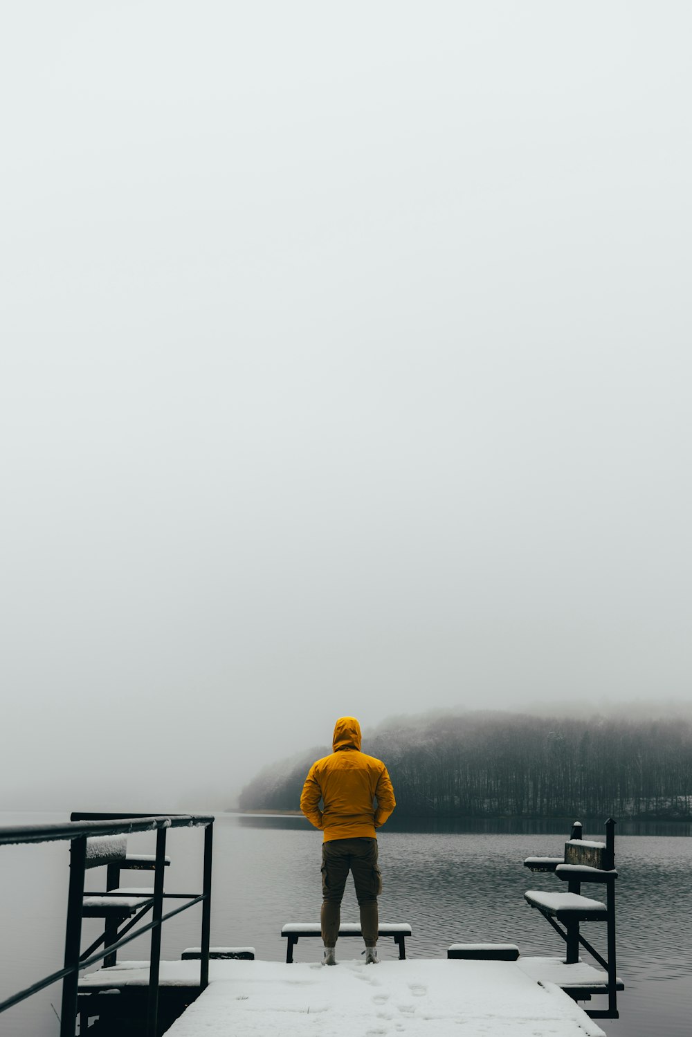 a man in a yellow jacket standing on a dock