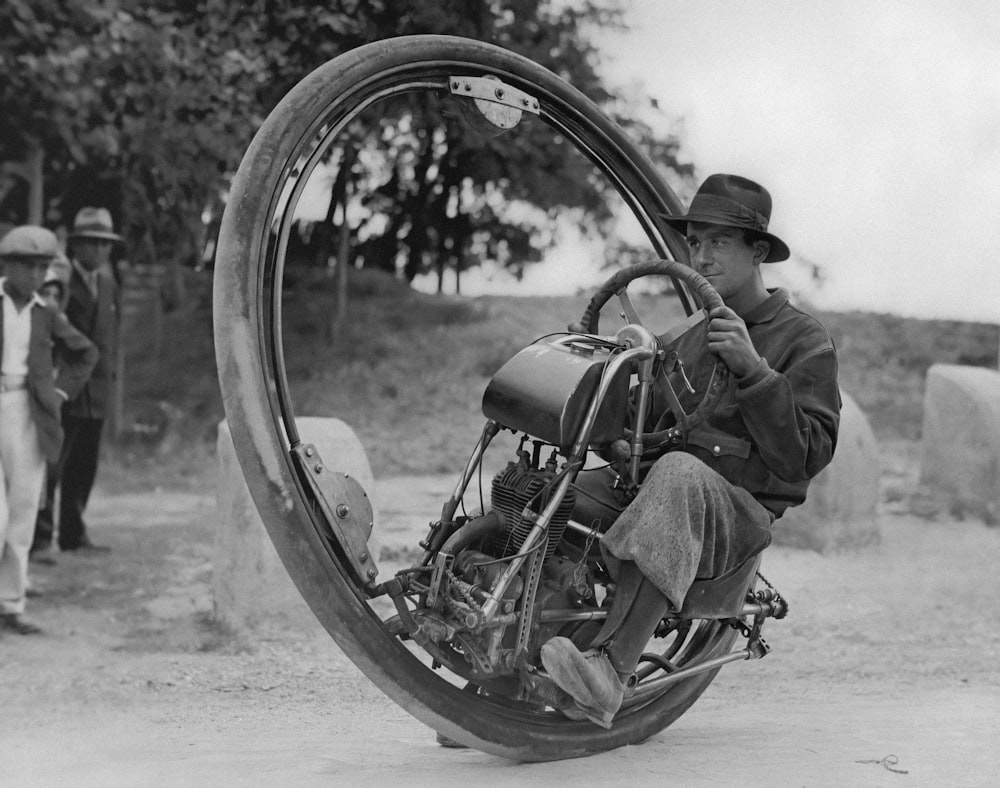 a man riding on the back of a motorcycle through a tire