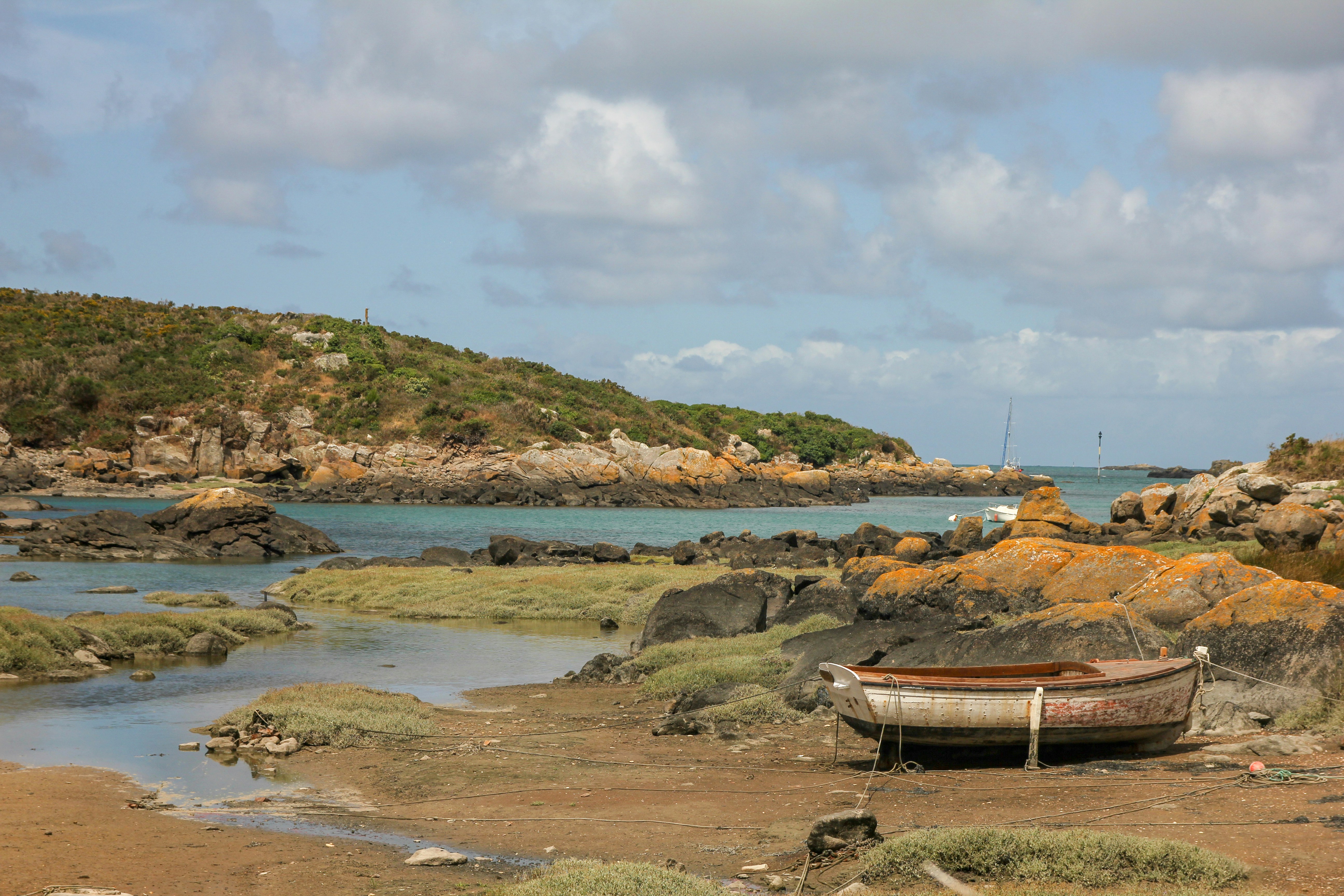 a boat sitting on top of a sandy beach