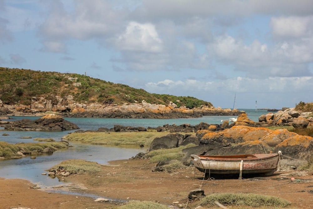 a boat sitting on top of a sandy beach