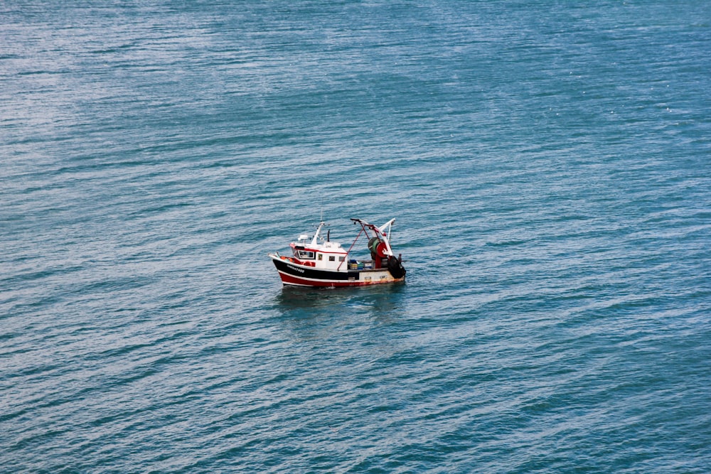 a small boat floating on top of a large body of water