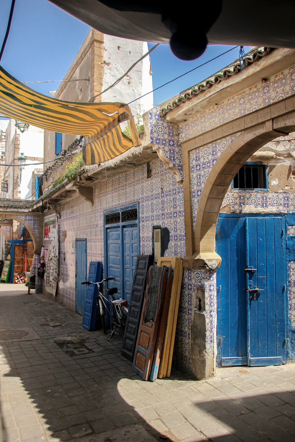 a narrow alleyway with a blue door and blue shutters