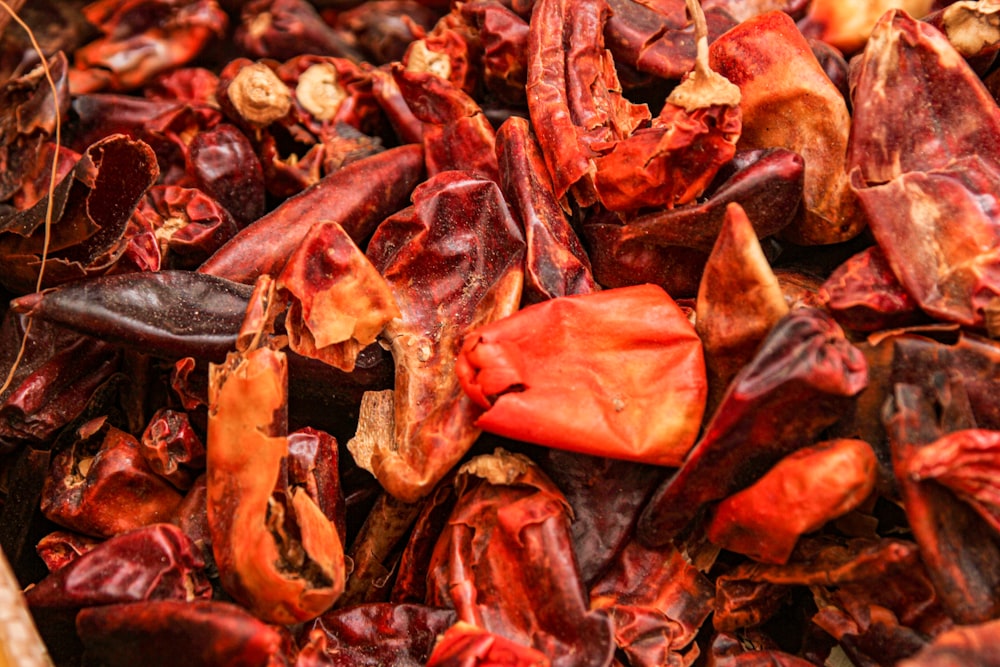 a pile of dried red peppers sitting on top of a table