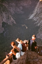 a group of people sitting on top of a mountain