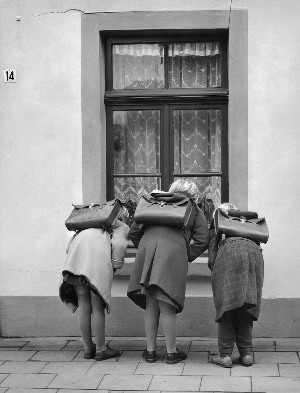 a group of women standing next to each other near a window
