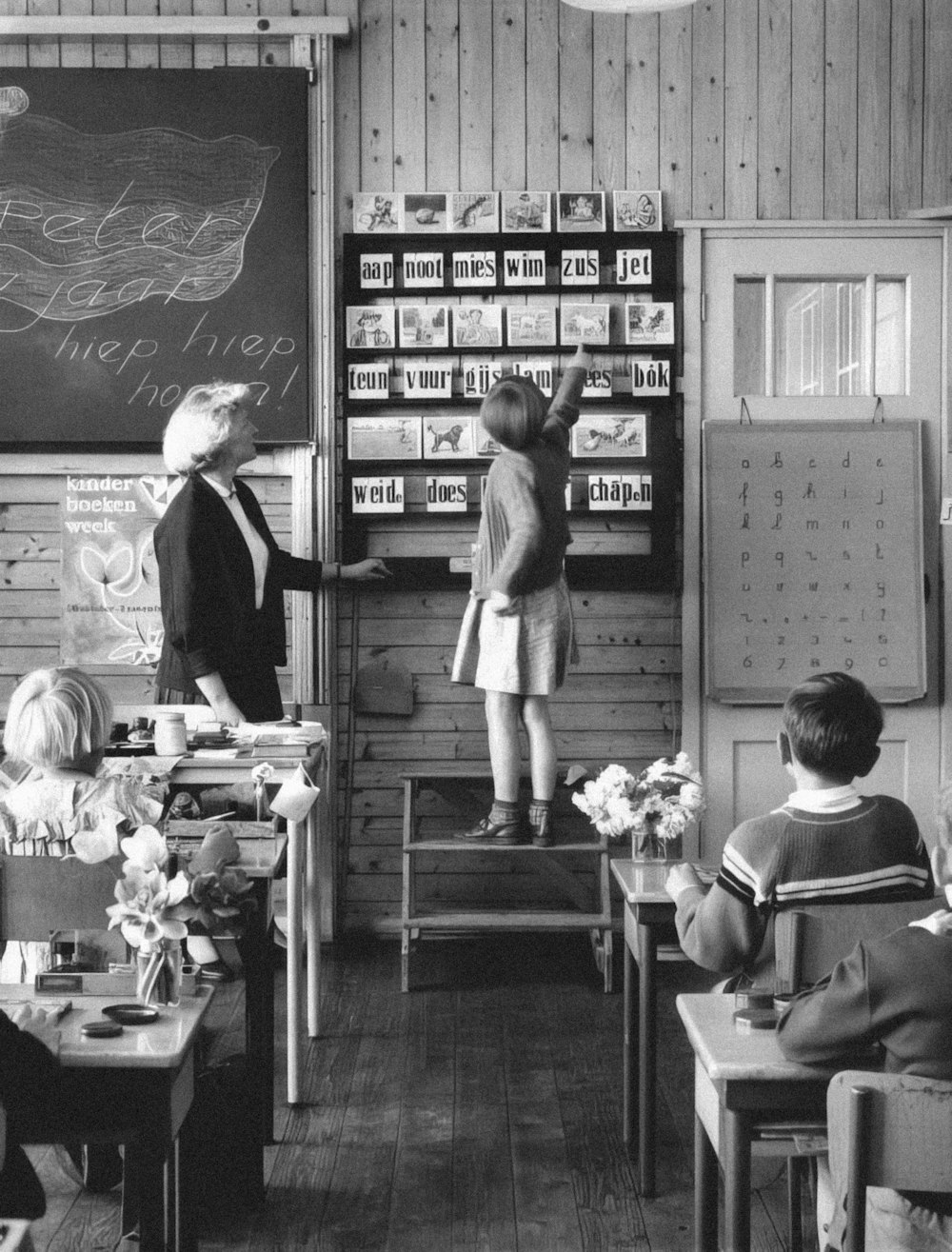 a black and white photo of children in a classroom