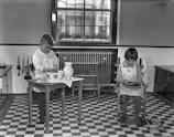 A volunteer helping a child with homework in a bright, welcoming kitchen space.
