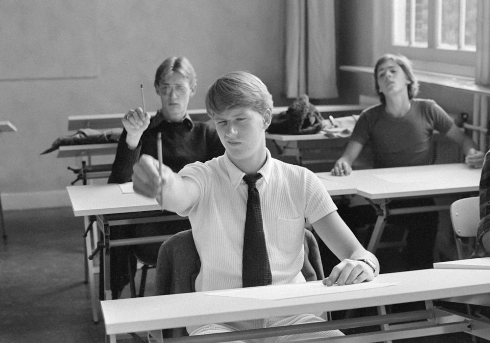 a group of people sitting at desks in a classroom