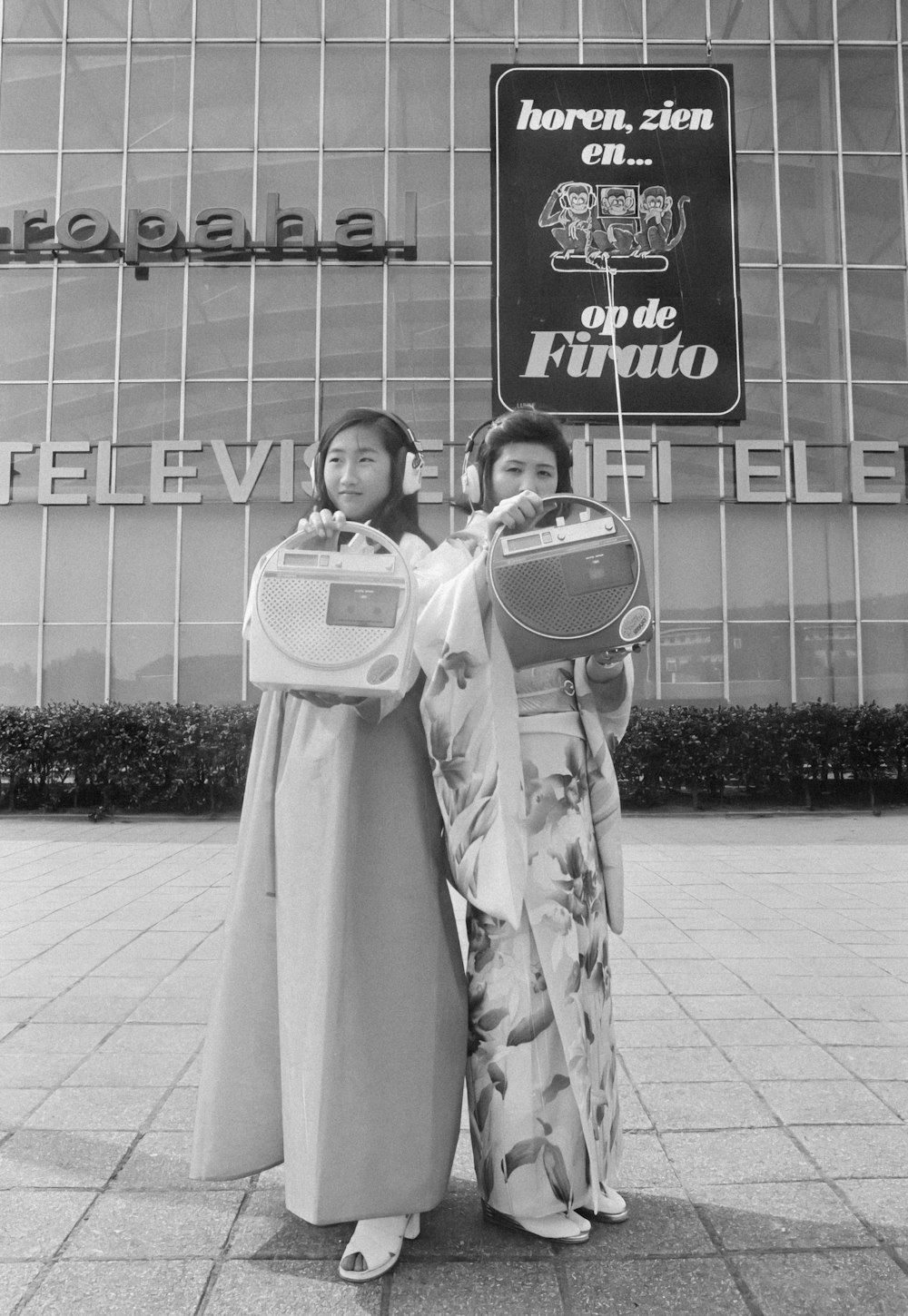 two women in kimonos standing in front of a building