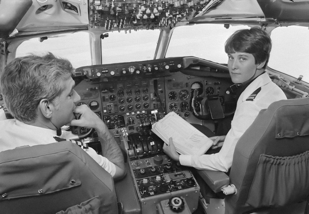 a couple of women sitting in the cockpit of a plane