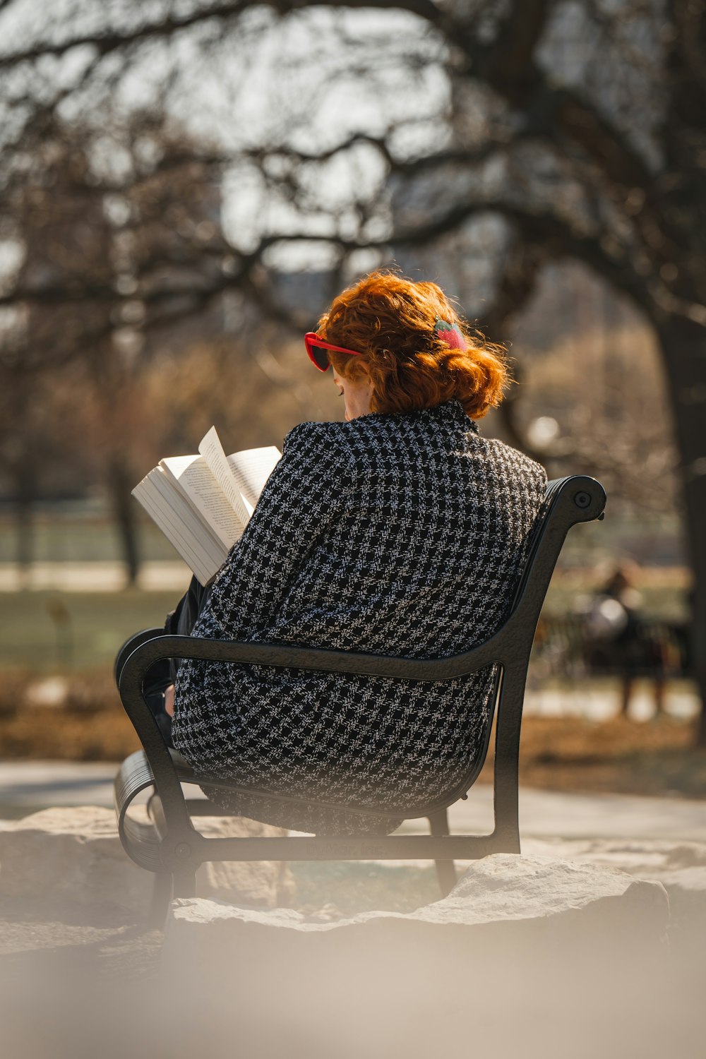a woman sitting on a bench reading a book