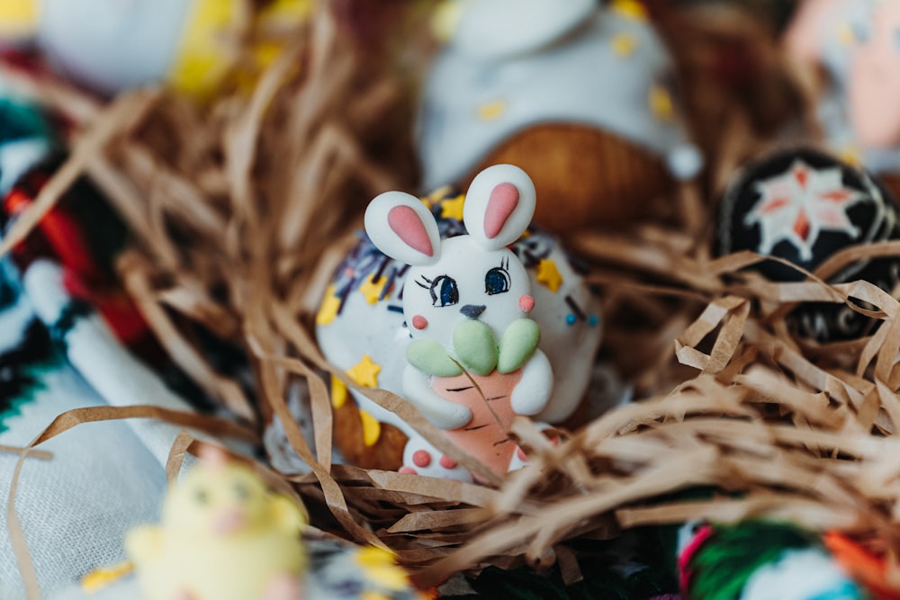 a bunny figurine sitting on top of a pile of fake eggs