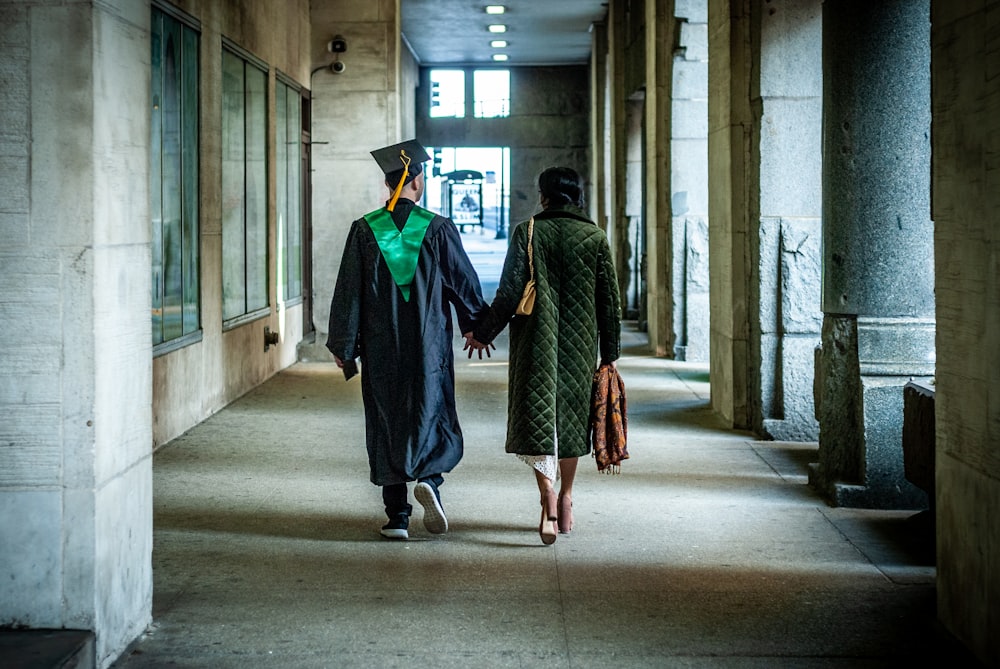 two people walking down a hallway holding hands
