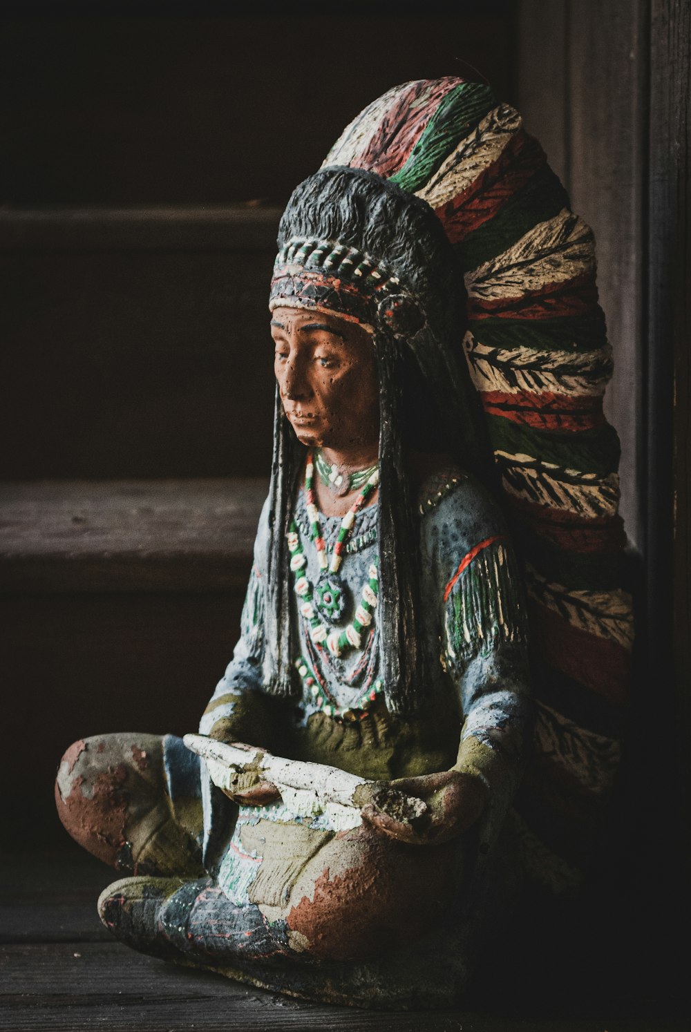 a statue of a person sitting on the ground