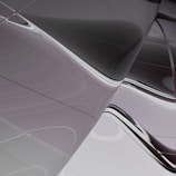 Smooth, reflective surfaces with sleek, flowing lines create a modern, abstract pattern. The curves and reflections suggest a futuristic or architectural theme.
