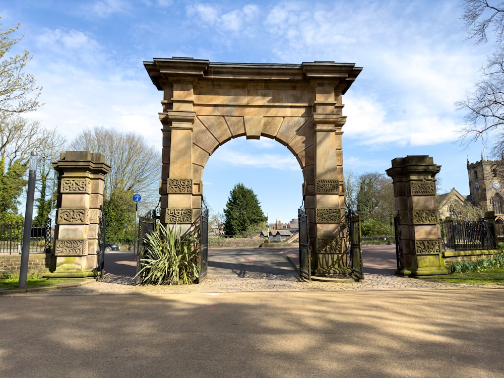 a large stone arch in the middle of a road