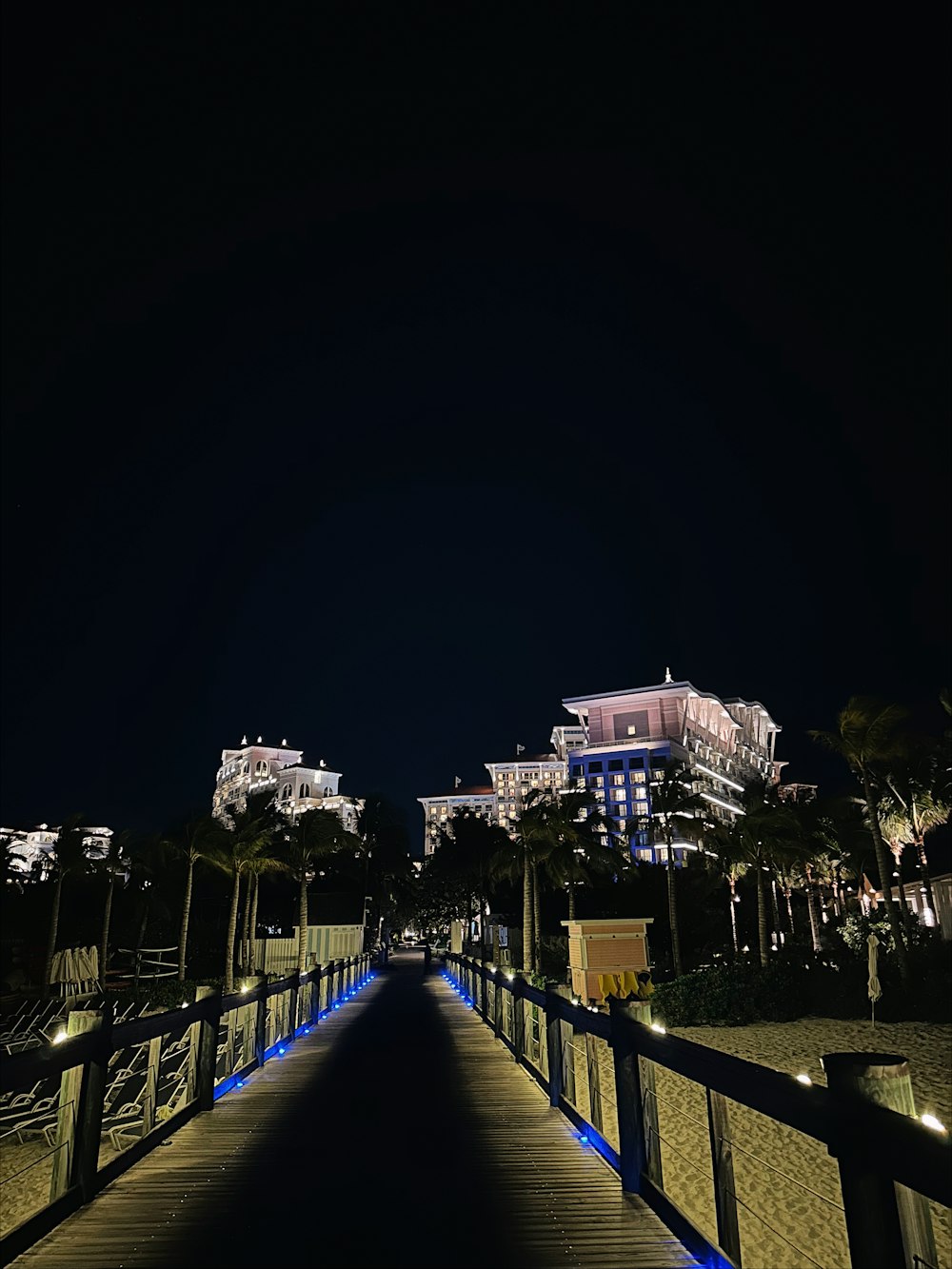 a walkway leading to a hotel at night
